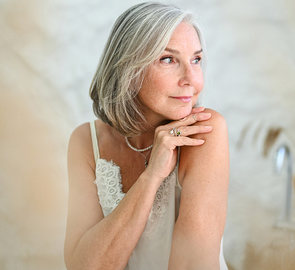 A silver-haired woman in soft natural light.