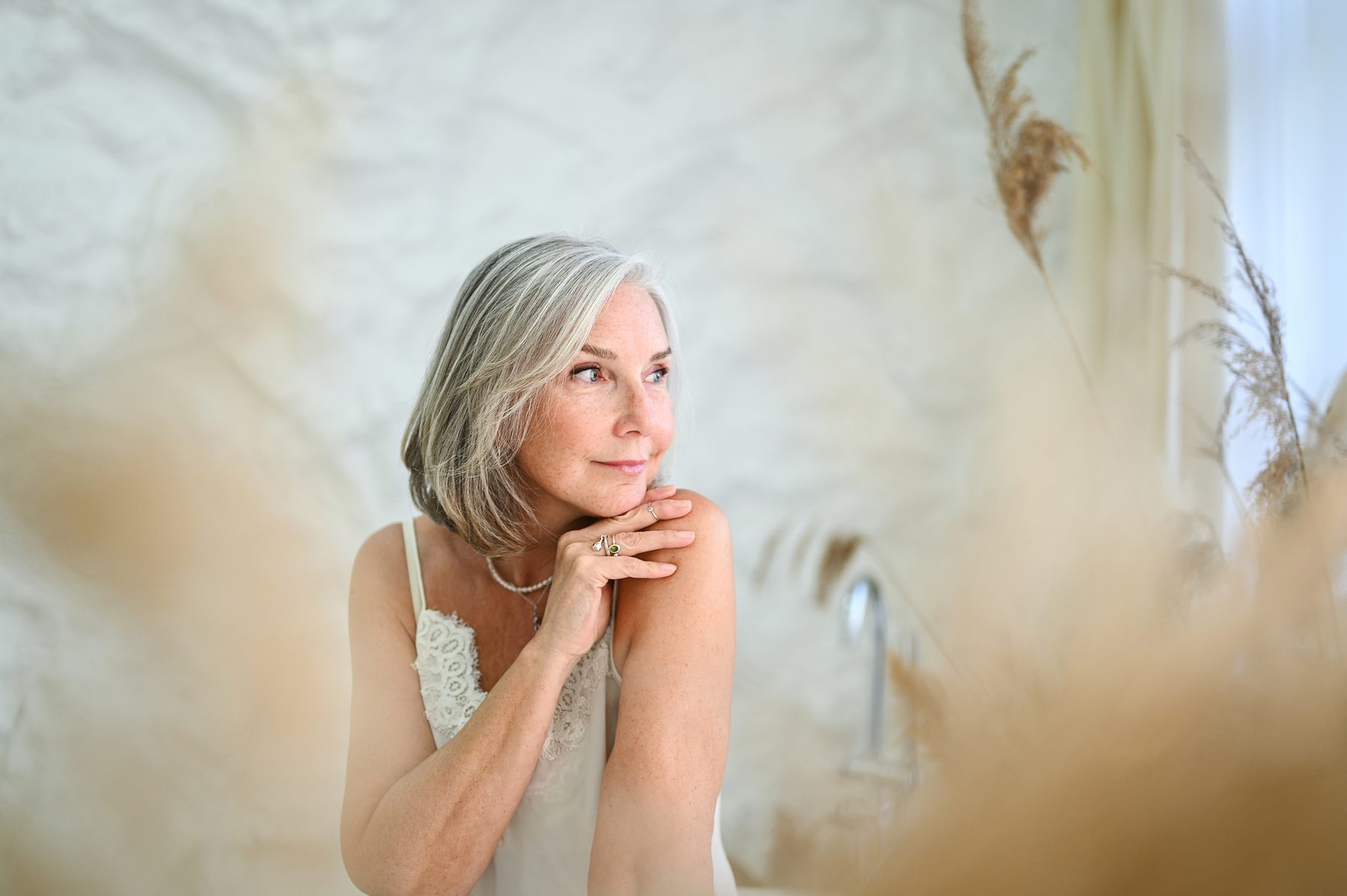 A silver-haired woman among pampas grass.