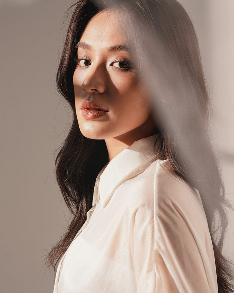 A woman in a white shirt turning into the light.